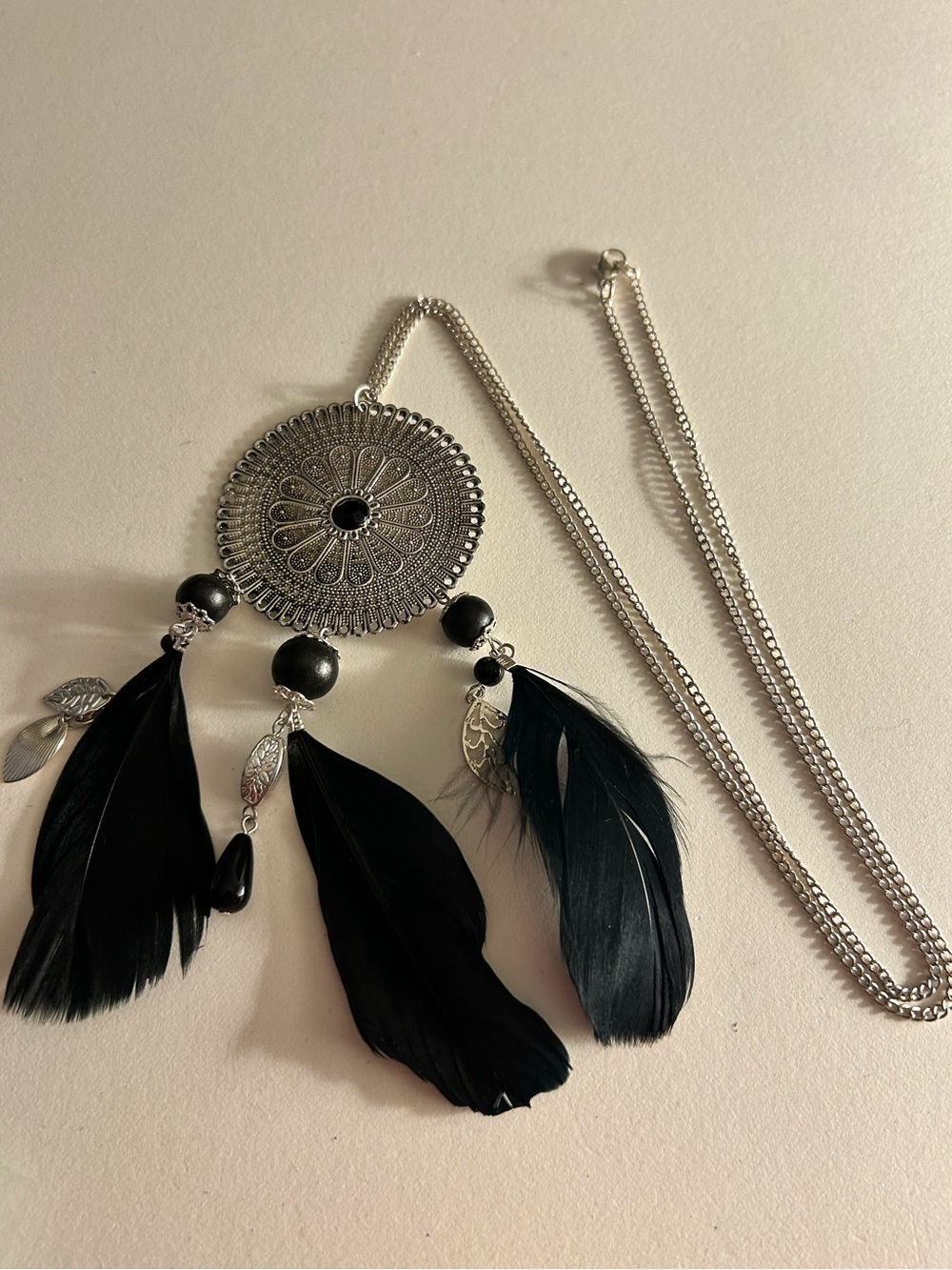 NWOT Necklace black feathers, charms, beads on silver etched disk 6”, chain 30”